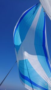 blue and white asymmetrical spinnaker set up on Beneteau first