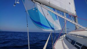 blue and white asymmetrical spinnaker set up on Beneteau